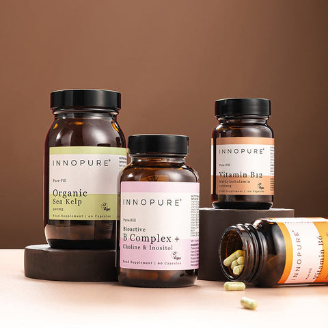 Collection of supplement bottles on a wooden surface with a brown background